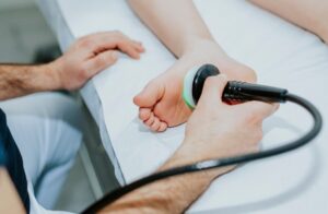 Medical professional using laser therapy device for athletes foot treatment