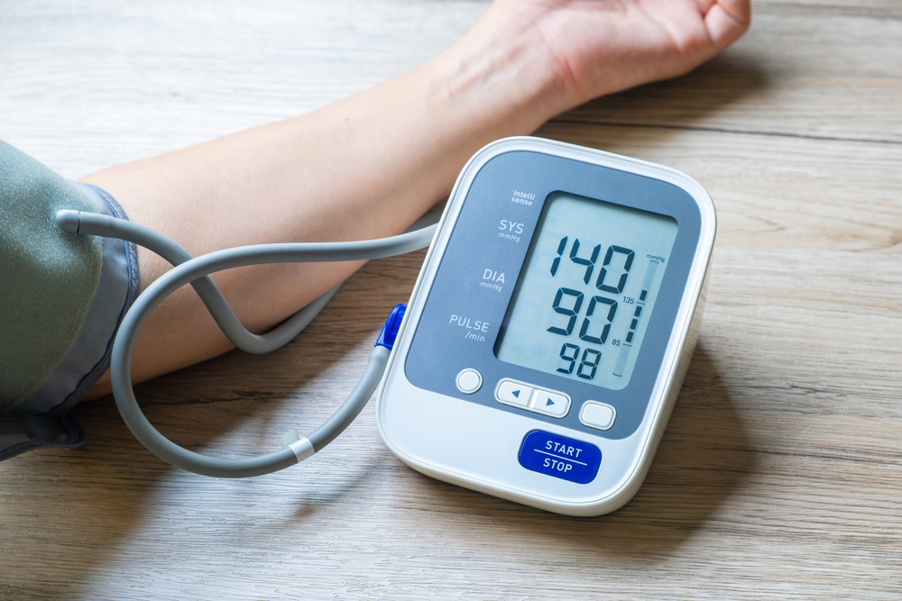 High blood pressure doctor measuring patient's blood pressure during consultation