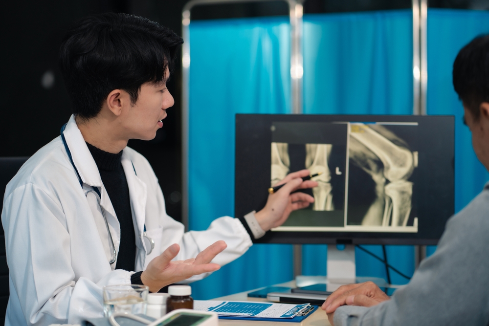 Knee pain specialist performing comprehensive knee examination on patient