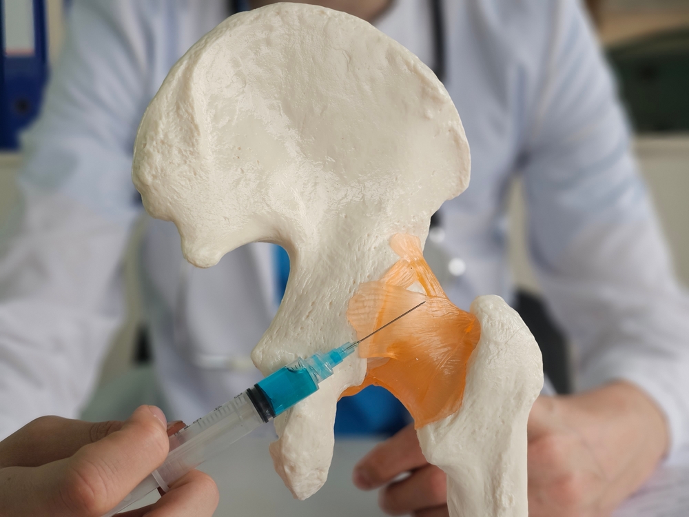 Doctor administering pain management injection knee treatment under ultrasound guidance