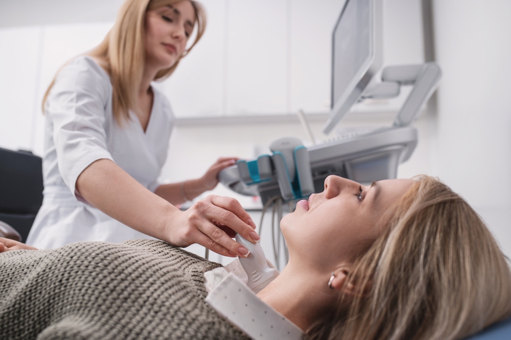 Healthcare provider performing thyroid ultrasound examination as part of autoimmune disease testing