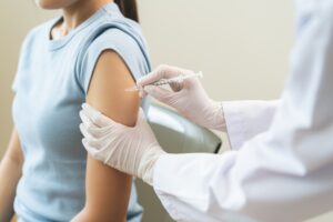 Medical professional preparing biotin injection with syringe and medication vial