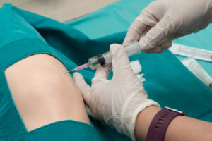 Medical professional preparing patient's shoulder for cortisone injection treatment