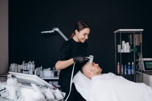 Patient receiving cryotherapy facial treatment from healthcare provider in clinical setting