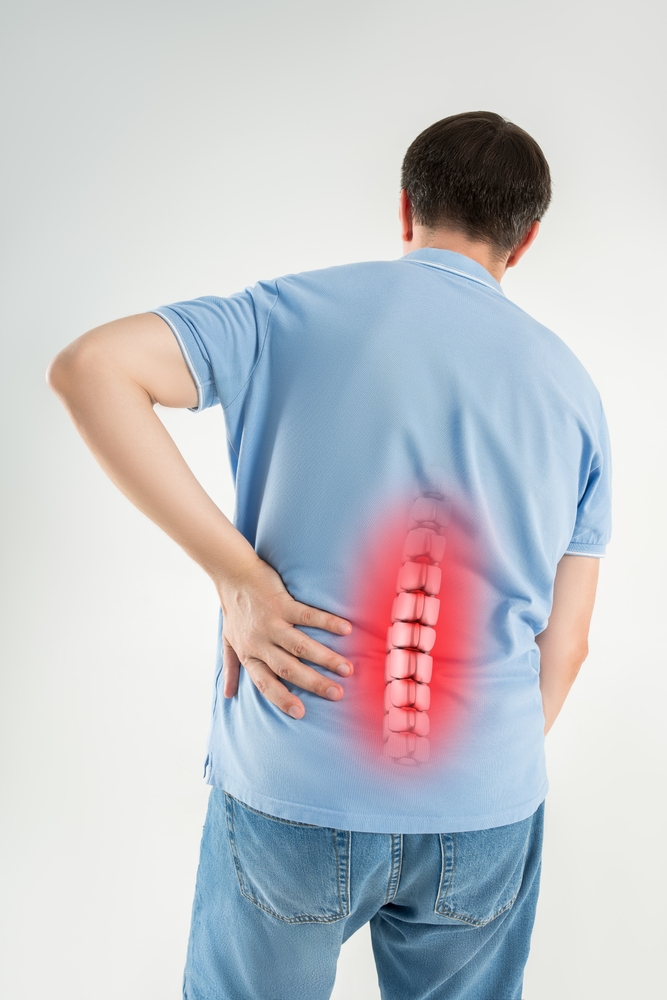 Man holding lower back with highlighted spine showing degenerative disc disease pain
