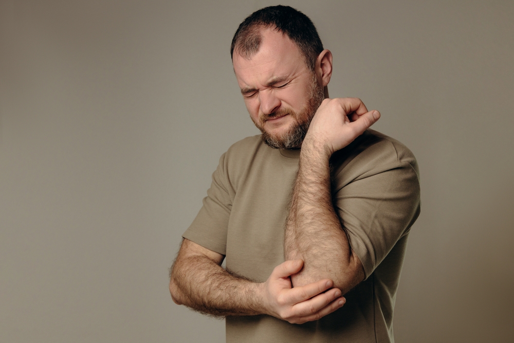 Doctor examining swollen elbow during elbow bursitis treatment consultation