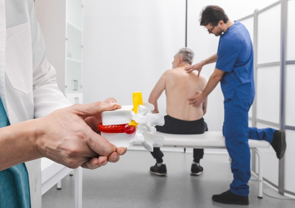 Medical team reviewing spine symptoms for herniated disc treatment's lower back during herniated disc treatment consultation
