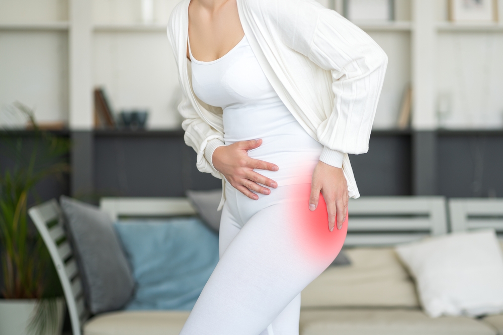 Physical therapist performing hip bursitis treatment stretching on patient