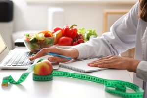 Person standing on bathroom scale tracking weight with hormone therapy