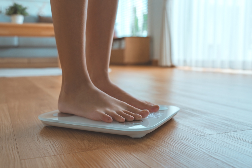 Feet on digital scale representing weight management with hormone therapy