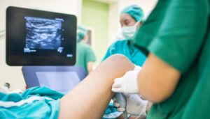 Physician administering nerve block injection to patient's shoulder area