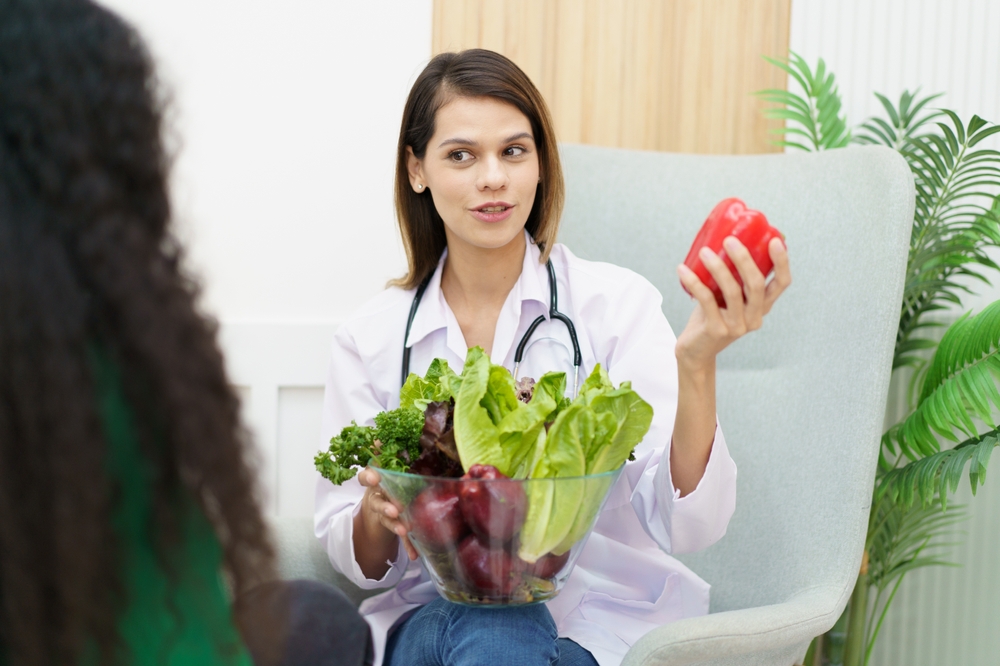Healthcare provider with fruits and vegetables discussing nutrition plan