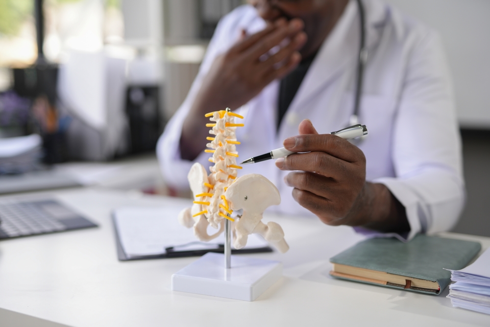 Spine specialist examining MRI images during patient consultation