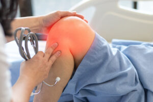 Doctor examining adolescent athlete's knee during sports medicine consultation