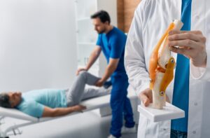 Sports medicine specialist evaluating athlete with patellar tendon pain