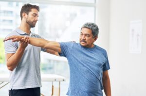 Physical therapist guiding patient through leg rehabilitation exercises