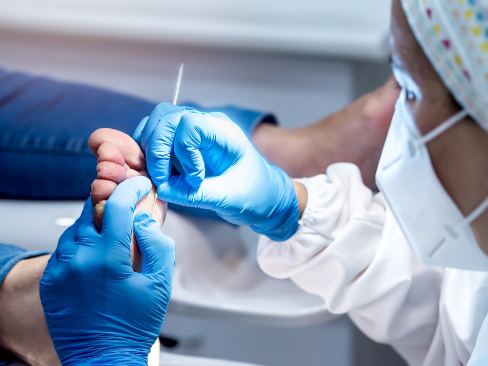 Podiatrist performing comprehensive foot examination on patient