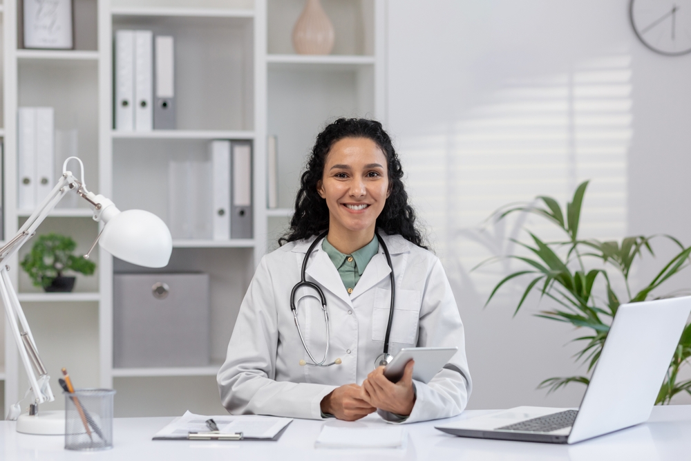 Female primary healthcare physician smiling at desk ready to help patients