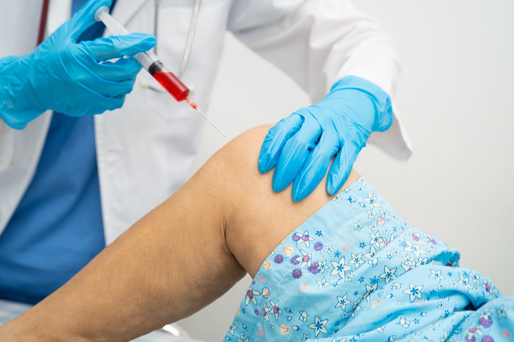 Medical provider performing ultrasound-guided PRP knee injection