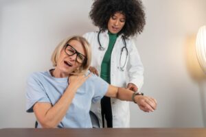 Doctor evaluating shoulder range of motion during rotator cuff assessment