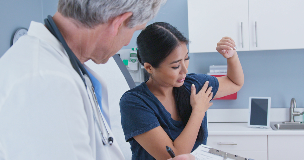 Healthcare provider examining shoulder mobility during rotator cuff tear evaluation's shoulder during rotator cuff tear treatment