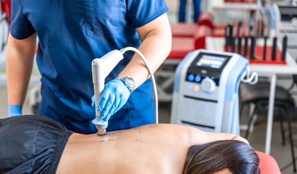 Medical professional performing shockwave therapy on patient's foot