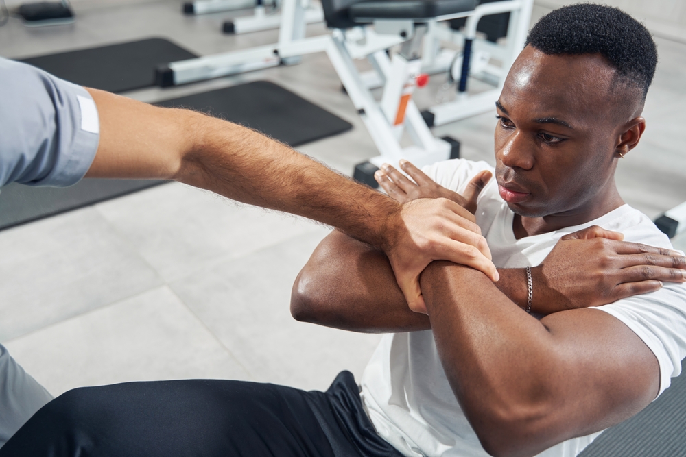 Performance trainer guiding athlete through specialized exercise
