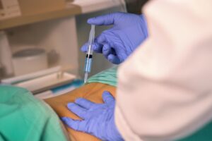 Physician administering epidural steroid injection to patient's lower back