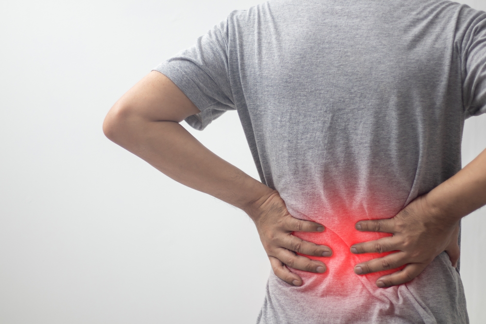 Medical professional performing spinal epidural injection with patient positioned for treatment