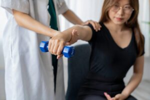 Physical therapist treating patient's tennis elbow with manual therapy