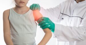 Doctor assessing shoulder with highlighted pain area indicating shoulder labrum injury location