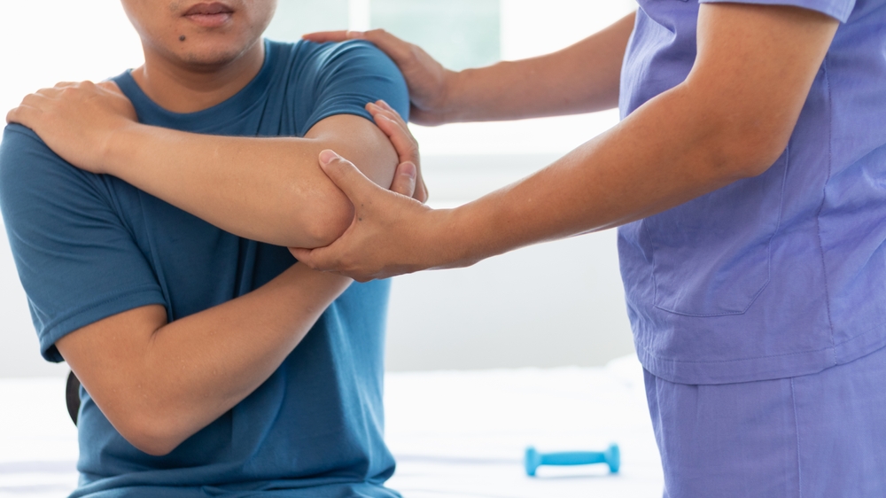 Medical provider examining patient's shoulder during treatment for labral tear of shoulder evaluation