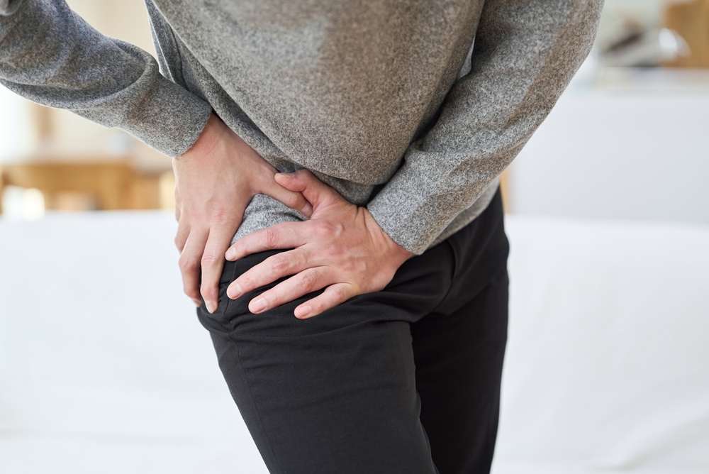 Person holding hip area experiencing symptoms requiring labral tear hip treatment