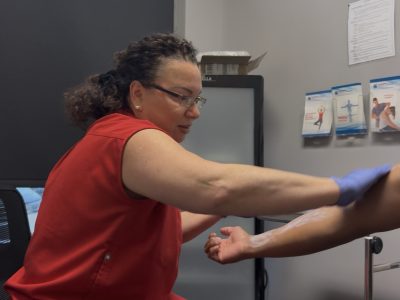 Person experiencing allergic skin reaction with hives on arm