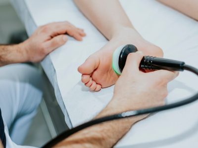 Medical professional using laser therapy device for athletes foot treatment