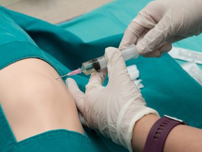 Medical professional preparing patient's shoulder for cortisone injection treatment