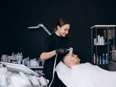 Patient receiving cryotherapy facial treatment from healthcare provider in clinical setting