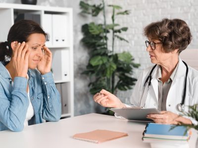 Exhausted patient consulting with chronic fatigue doctor about persistent tiredness symptoms