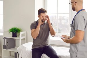 Fatigued male patient discussing fatigue and tiredness treatment options with healthcare provider