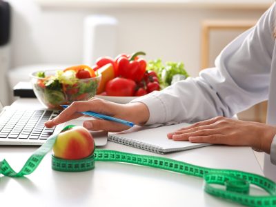 Person standing on bathroom scale tracking weight with hormone therapy