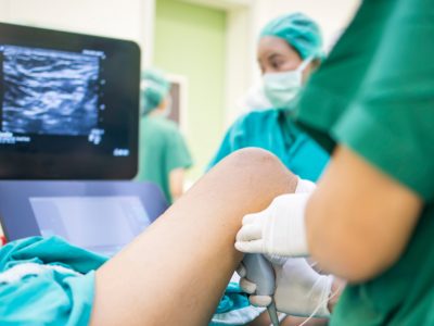 Physician administering nerve block injection to patient's shoulder area
