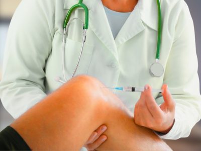 Medical professional preparing cortisone injections knee for patient