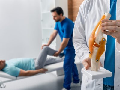 Sports medicine specialist evaluating athlete with patellar tendon pain
