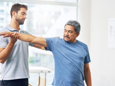 Physical therapist guiding patient through leg rehabilitation exercises