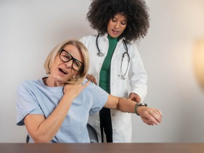 Doctor evaluating shoulder range of motion during rotator cuff assessment