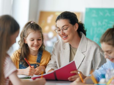 Happy,Kids,And,Teacher,At,School.,Woman,And,Children,Are
