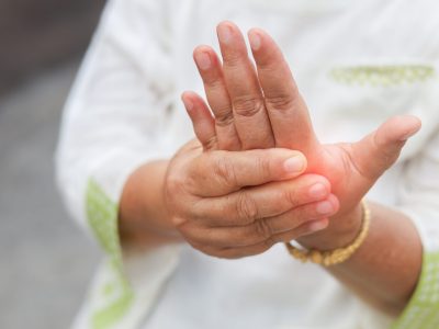 Person holding inflamed hand showing symptoms requiring tendonitis in hand treatment