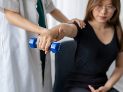 Physical therapist treating patient's tennis elbow with manual therapy